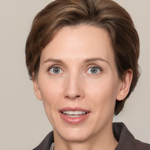 Joyful white adult female with medium  brown hair and grey eyes