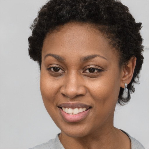 Joyful black young-adult female with short  brown hair and brown eyes
