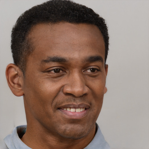 Joyful black young-adult male with short  brown hair and brown eyes