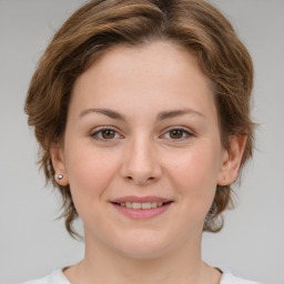 Joyful white young-adult female with medium  brown hair and green eyes