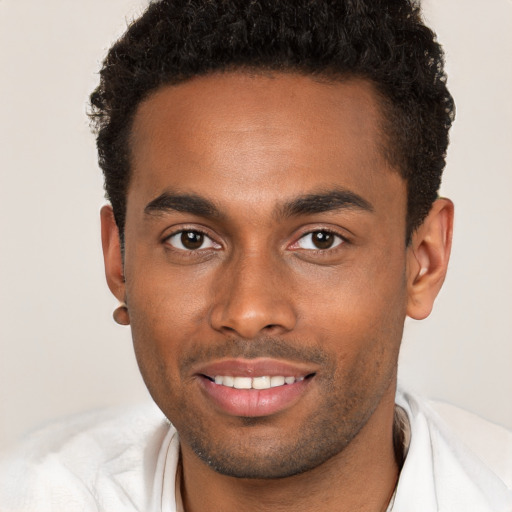 Joyful black young-adult male with short  brown hair and brown eyes