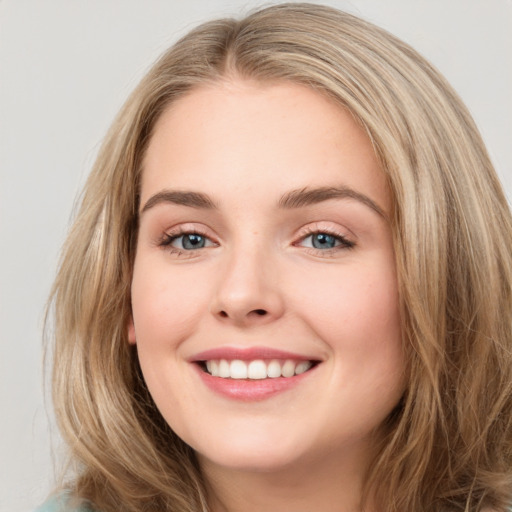 Joyful white young-adult female with long  brown hair and green eyes