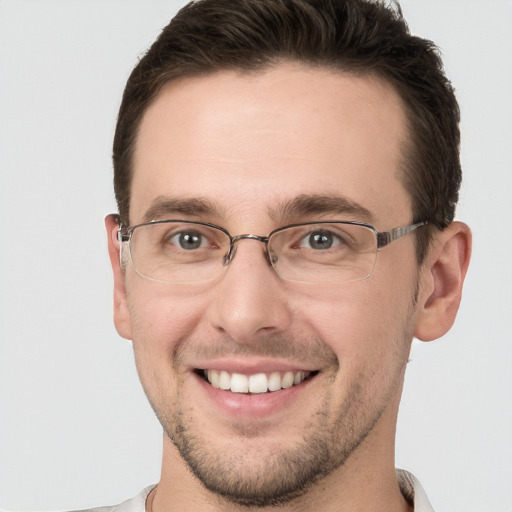 Joyful white young-adult male with short  brown hair and grey eyes