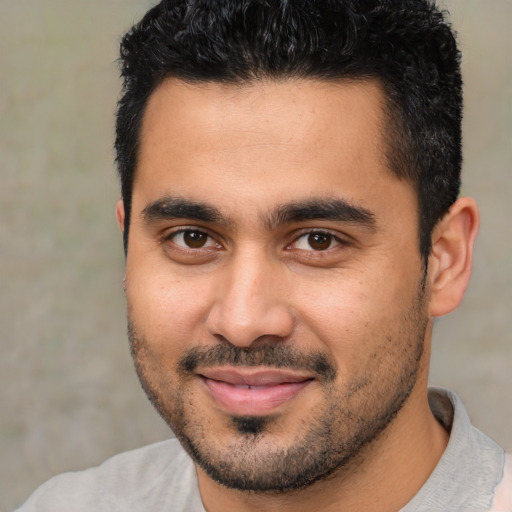 Joyful latino young-adult male with short  black hair and brown eyes