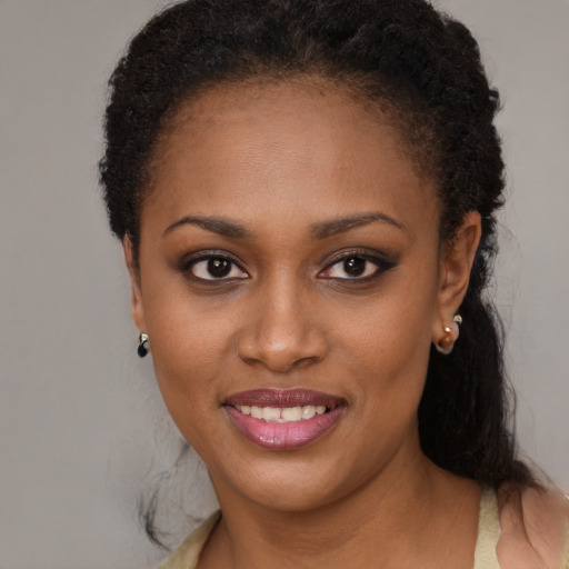 Joyful black young-adult female with long  black hair and brown eyes