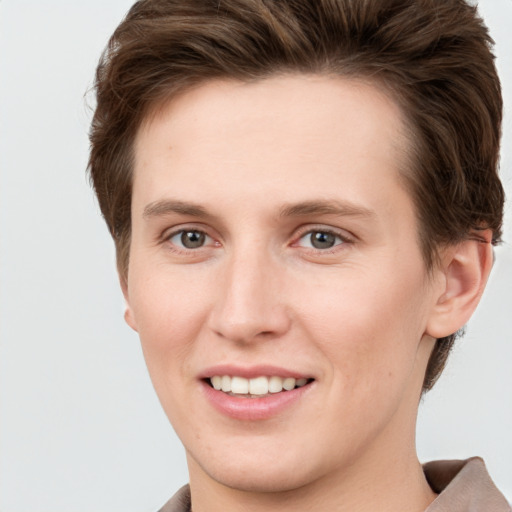 Joyful white young-adult female with short  brown hair and grey eyes