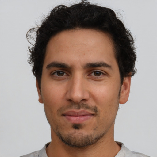 Joyful latino young-adult male with short  black hair and brown eyes