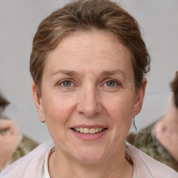 Joyful white adult female with medium  brown hair and grey eyes