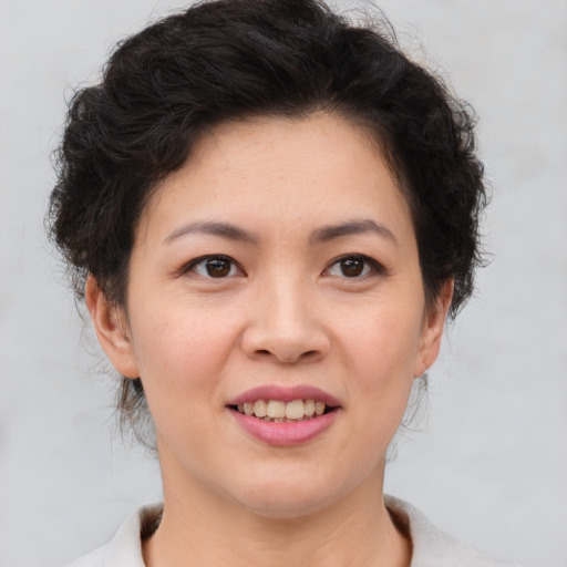 Joyful asian young-adult female with short  brown hair and brown eyes