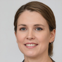 Joyful white young-adult female with medium  brown hair and grey eyes