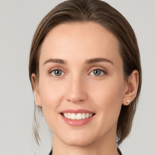 Joyful white young-adult female with medium  brown hair and grey eyes