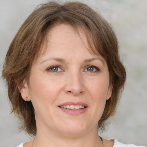 Joyful white adult female with medium  brown hair and blue eyes