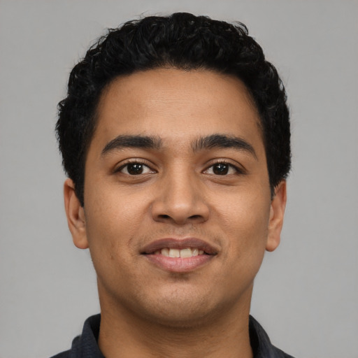 Joyful latino young-adult male with short  black hair and brown eyes