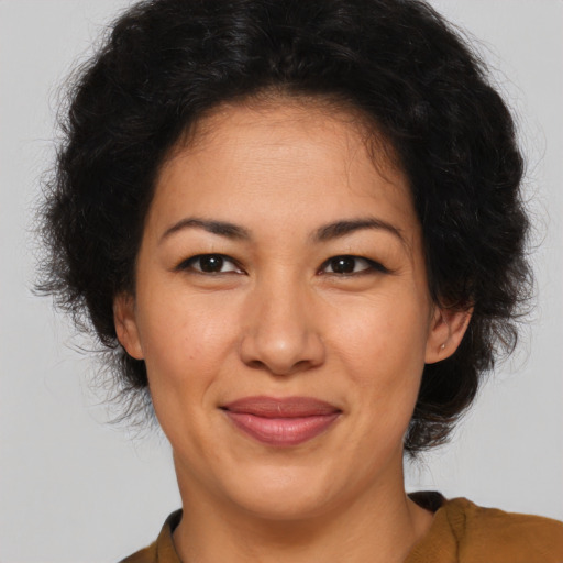 Joyful latino adult female with medium  brown hair and brown eyes