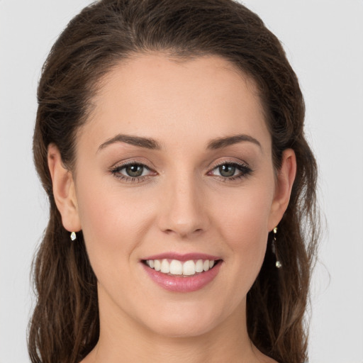 Joyful white young-adult female with long  brown hair and grey eyes