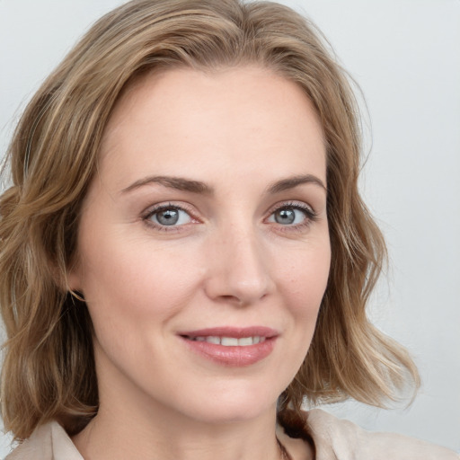 Joyful white young-adult female with medium  brown hair and blue eyes