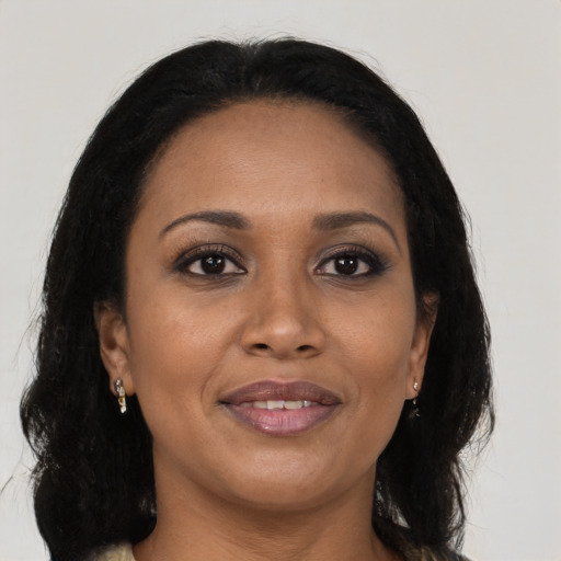 Joyful black young-adult female with long  brown hair and brown eyes
