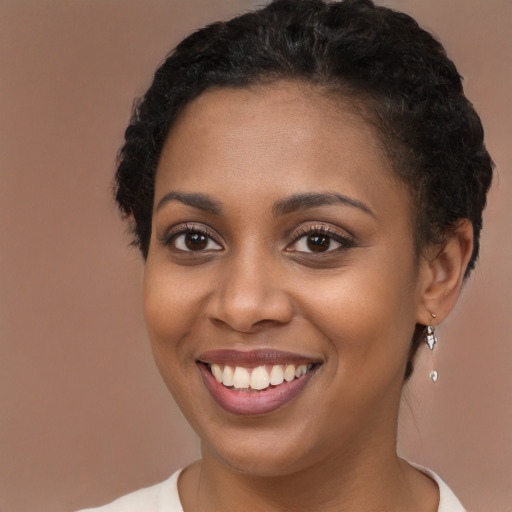 Joyful black young-adult female with short  brown hair and brown eyes