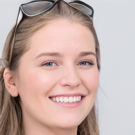 Joyful white young-adult female with long  brown hair and blue eyes