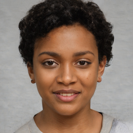 Joyful black young-adult female with short  black hair and brown eyes
