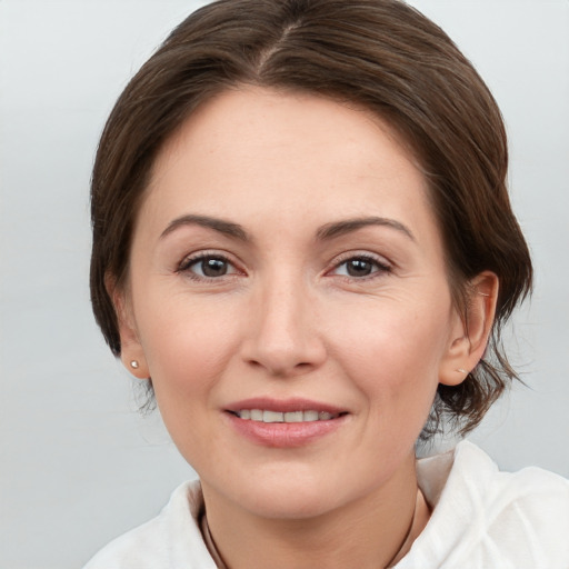 Joyful white adult female with medium  brown hair and grey eyes