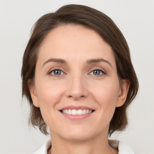 Joyful white young-adult female with medium  brown hair and green eyes