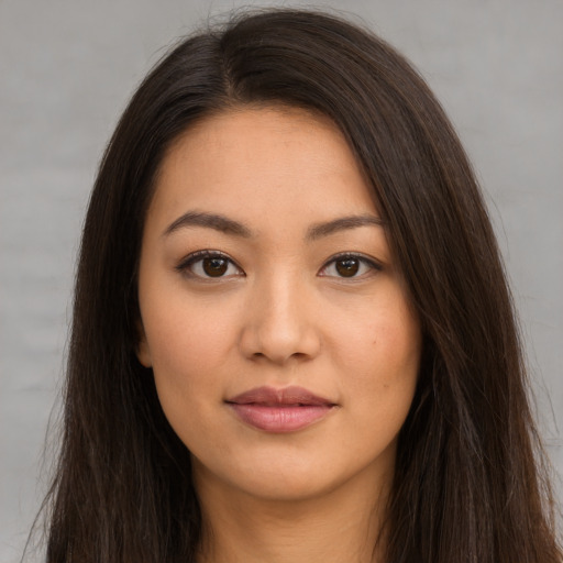 Joyful latino young-adult female with long  brown hair and brown eyes