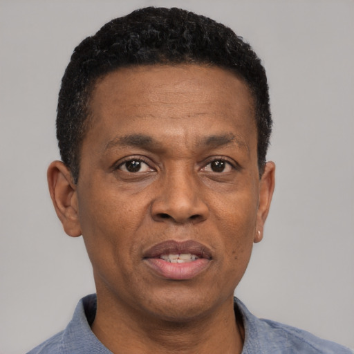 Joyful black adult male with short  black hair and brown eyes