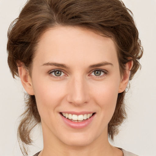 Joyful white young-adult female with medium  brown hair and green eyes