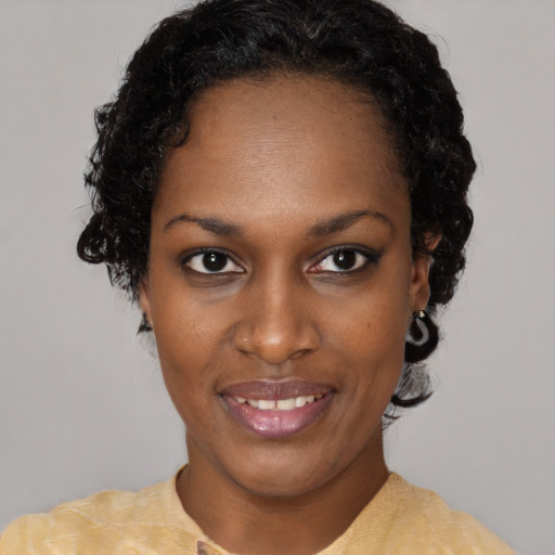 Joyful black young-adult female with short  black hair and brown eyes