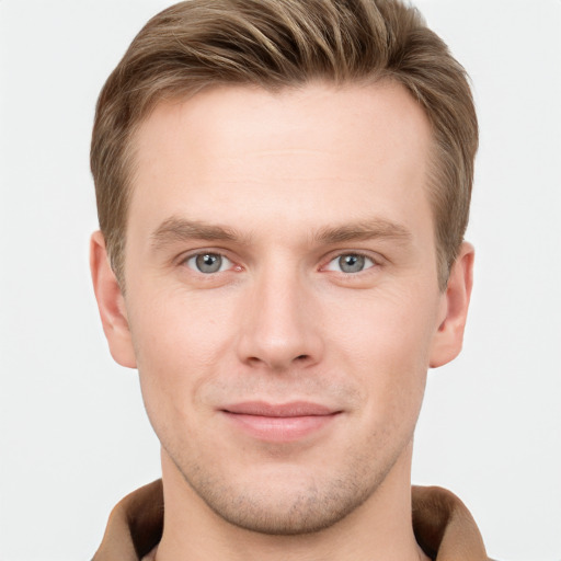 Joyful white young-adult male with short  brown hair and grey eyes