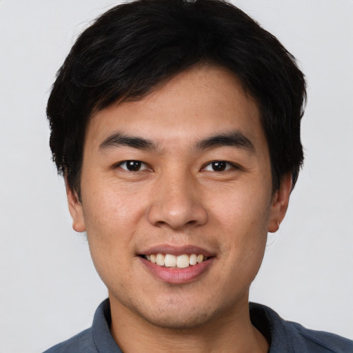 Joyful asian young-adult male with short  black hair and brown eyes