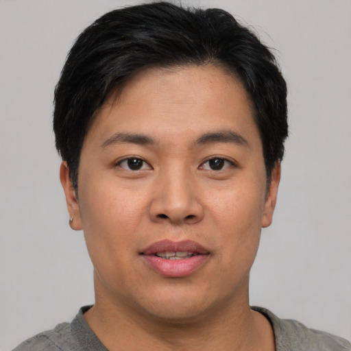 Joyful asian young-adult male with short  black hair and brown eyes