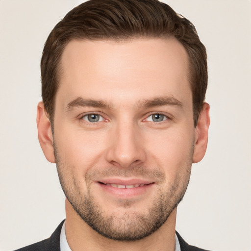 Joyful white young-adult male with short  brown hair and grey eyes