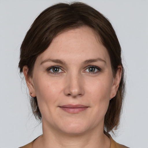 Joyful white adult female with medium  brown hair and grey eyes