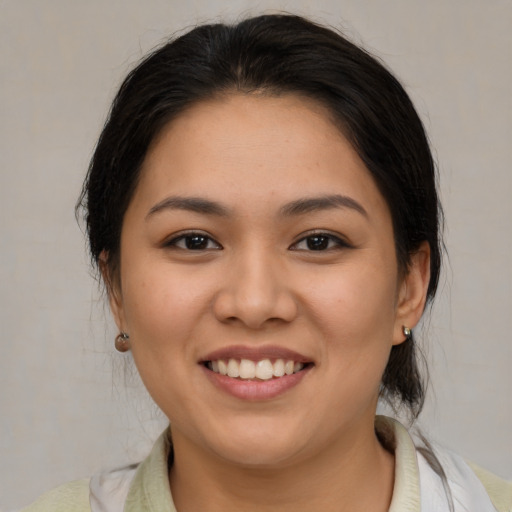 Joyful latino young-adult female with medium  brown hair and brown eyes