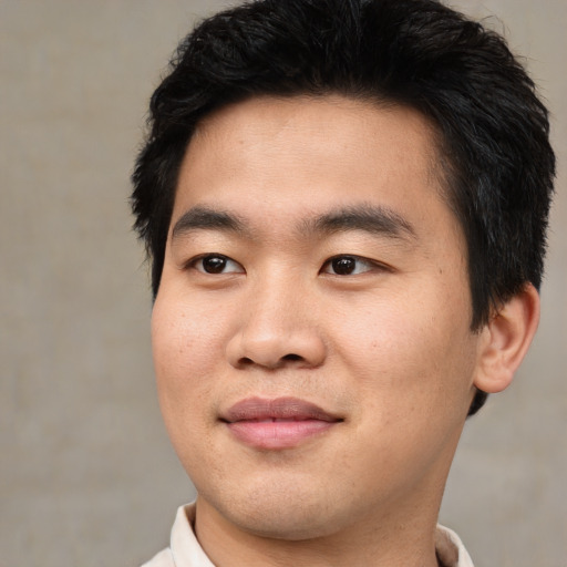 Joyful asian young-adult male with short  brown hair and brown eyes