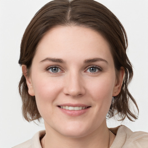 Joyful white young-adult female with medium  brown hair and grey eyes