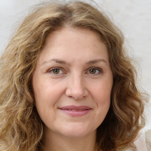 Joyful white adult female with long  brown hair and green eyes