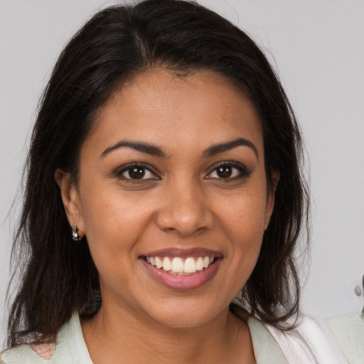 Joyful latino young-adult female with medium  brown hair and brown eyes