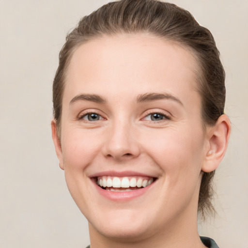 Joyful white young-adult female with short  brown hair and grey eyes