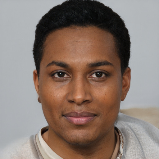 Joyful black young-adult male with short  black hair and brown eyes