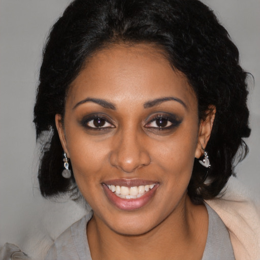 Joyful black young-adult female with long  black hair and brown eyes