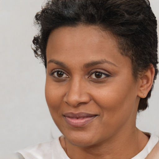 Joyful black young-adult female with short  brown hair and brown eyes