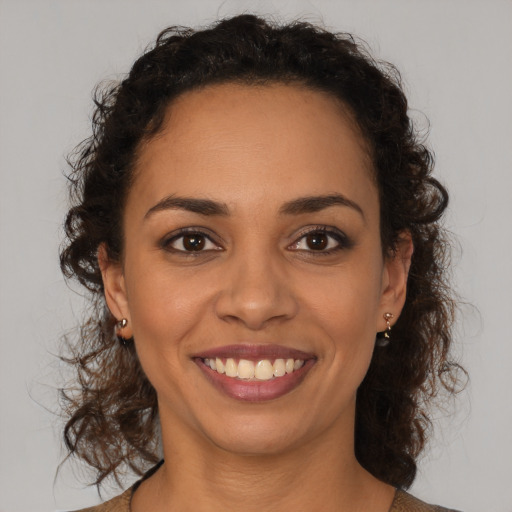 Joyful latino young-adult female with medium  brown hair and brown eyes