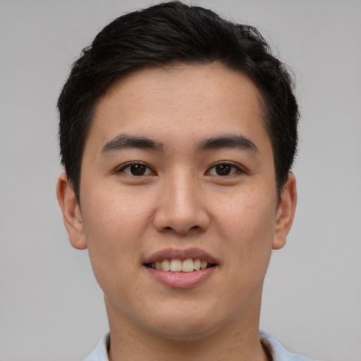 Joyful asian young-adult male with short  brown hair and brown eyes