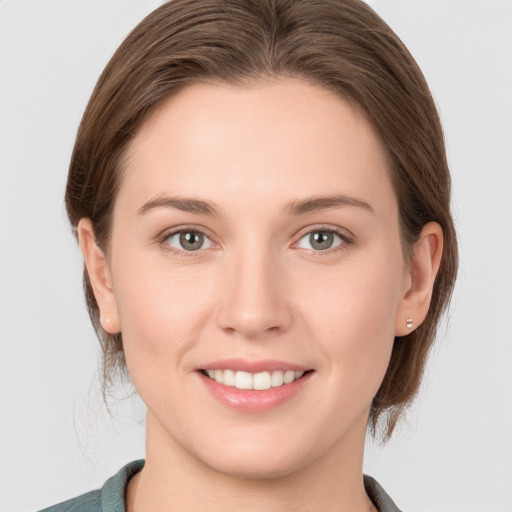 Joyful white young-adult female with medium  brown hair and grey eyes