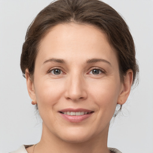 Joyful white young-adult female with short  brown hair and grey eyes