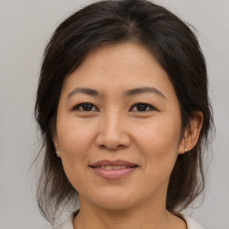 Joyful asian adult female with medium  brown hair and brown eyes