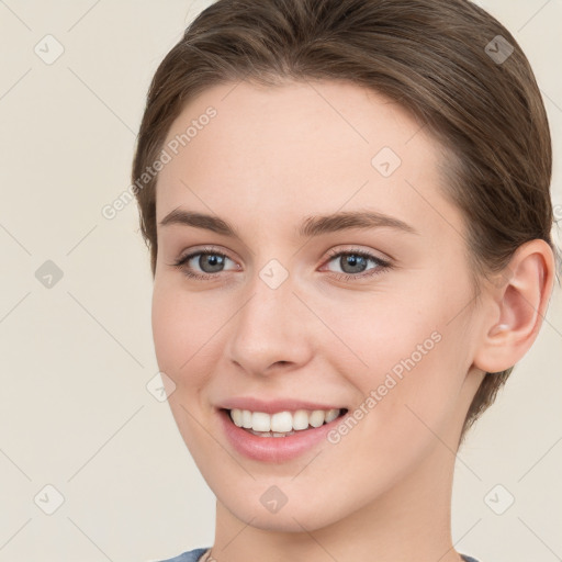 Joyful white young-adult female with medium  brown hair and grey eyes